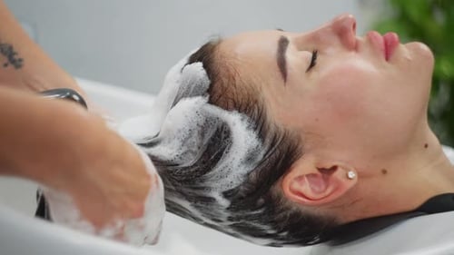 Woman Relaxing While Having Hair Shampooed at Salon