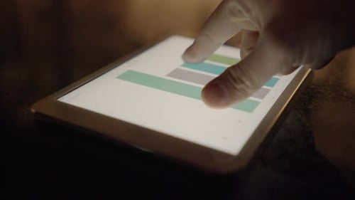 dolly tracking shot around digital tablet computer showing business charts
