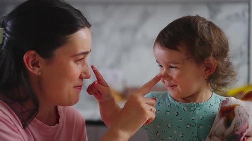 Mother and Baby Touching Noses with Food