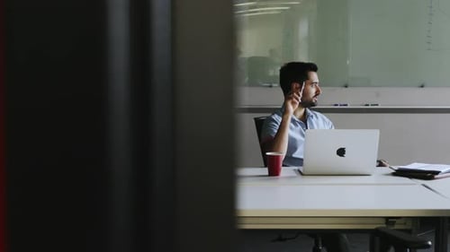 Man Thinks at Desk in Modern Office