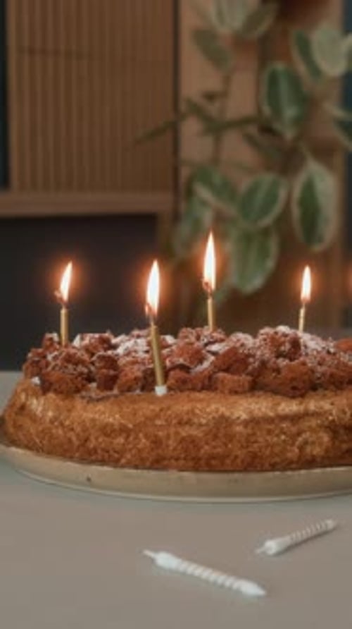 Vertical of Candles Burning on Homemade Birthday Cake in Cozy Kitchen