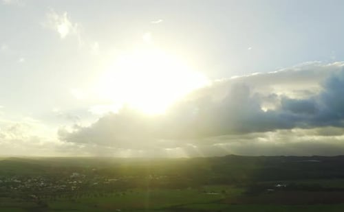 Sun Rays over Green Countryside from Above