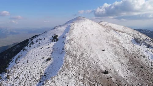 Orbe aérienne panoramique des montagnes du Péloponnèse couvertes de neige avec une ligne de crête projetant de l'ombre