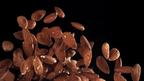 Almonds Falling in Slow Motion on Black Background