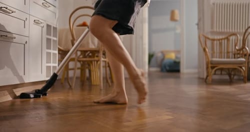 Vacuuming Parquet Wood Floor in Home