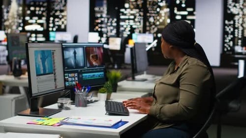 Woman Works on Computer Editing Video at Desk