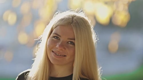 Smiling Young Woman with Blonde Hair Outdoors