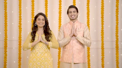 Smiling Young Couple in Festive Attire Greeting