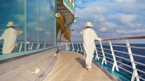 Woman Strolls on Cruise Ship Deck Overlooking Ocean