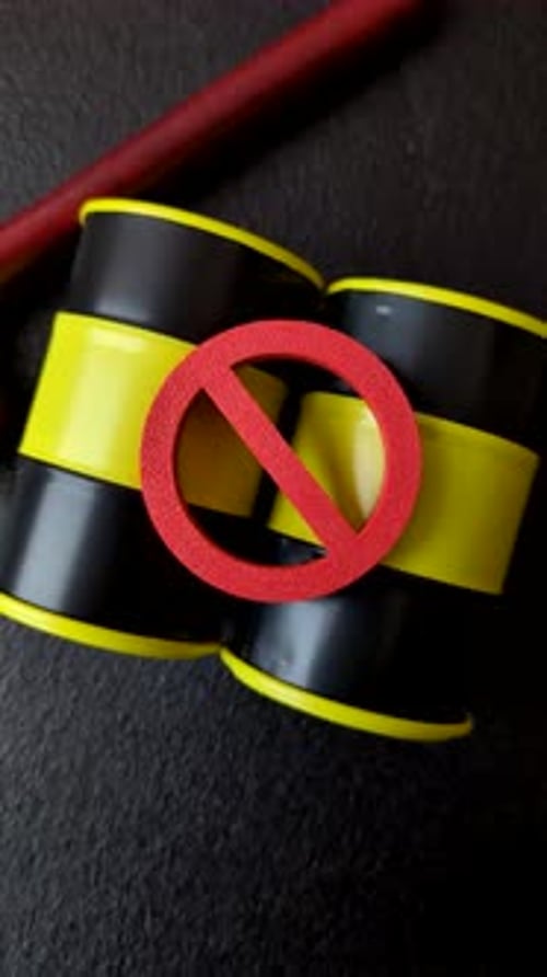Metal barrels containing oil, gas, or chemicals, with a prohibition sign. Oil barrels