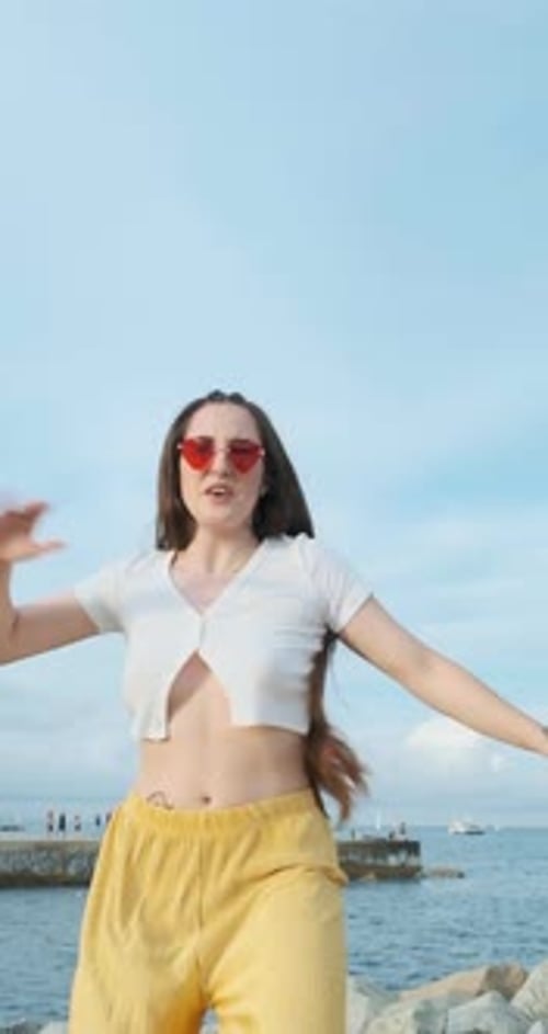 Stylish Woman Dancing on Pier by the Sea