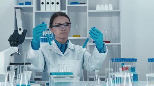 Female Scientist Examining Test Tubes in Laboratory