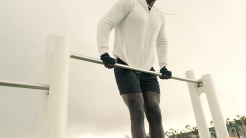 Man doing pull-ups on a horizontal bar, street workout