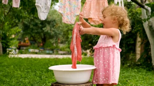 The Child is Washing Clothes in the Garden Selective Focus