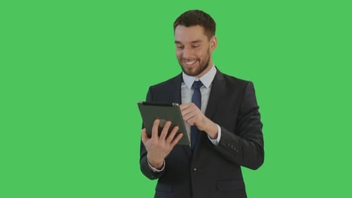 Imagen mediana de un apuesto hombre de negocios sonriente haciendo gestos de deslizar el dedo en una tableta.
Antecedentes