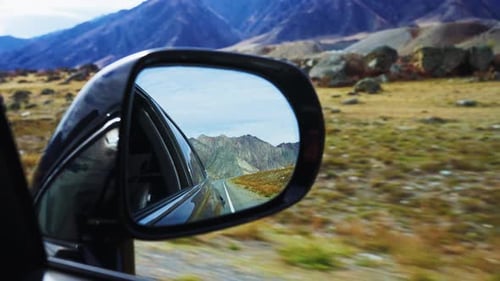 Scenic Car Journey Reflection Majestic Mountains Visible in Side Mirror During an Amazing Drive