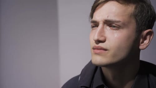 Un joven que llora triste.