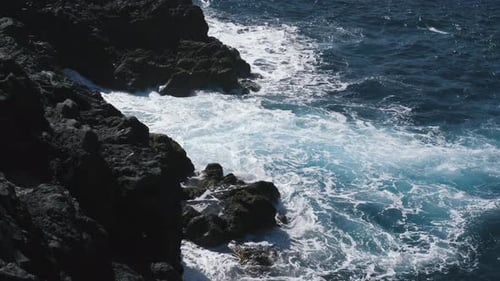 Eine große Welle des Atlantiks bricht an einer Felsenküste an einem sonnigen Tag während eines Sturms in der