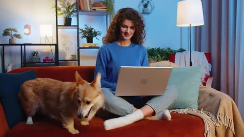 Woman Works on Laptop with Dog at Home