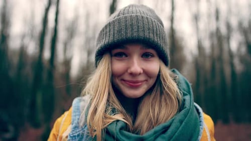 Portrait of Blonde Young Smiling Girl in Autumn Forest Looking at Camera Woman Standing in Forest
