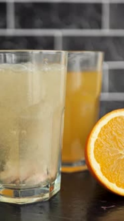 Vertical: two tablets of a fast-dissolving effervescent antipyretic agent falling into water in a gl