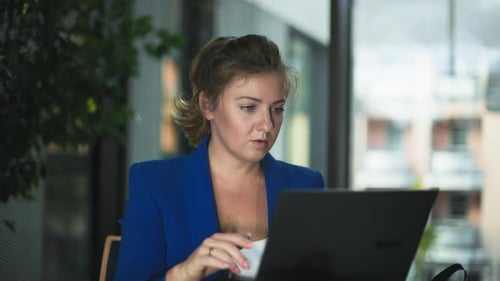 Home Office Young Beautiful Woman Working at a Laptop While Sitting Compiling Reports While Sitting