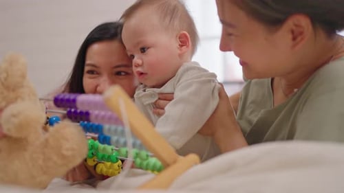 Loving Women and Infant Playing with Toys Indoors