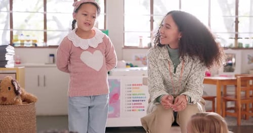 Young Girl Speaking to Teacher in Classroom