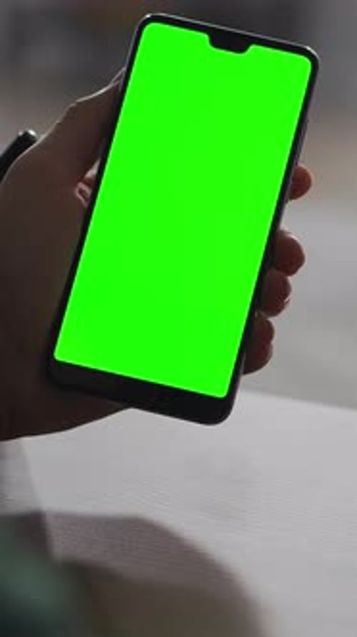 Person Holding Modern Smartphone with Vivid Green Chroma Key Screen in Closeup View Showcasing Blank