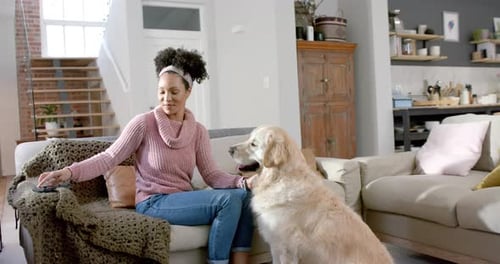 Woman Petting Golden Retriever Dog on Couch