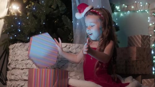 Excited Girl Opening Glowing Christmas Gift