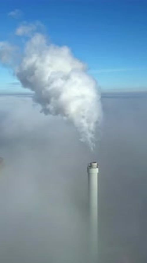 Industrial Smokestack Emitting Plumes of Smoke on Clear Day