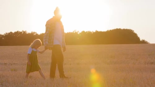 Two Silhouettes Outdoors in Sunrise Family Father Dad Man Farmer Walking in Wheat Field with Little
