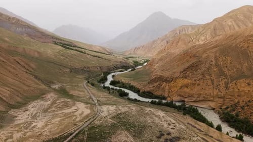 Kurvenreicher Fluss durch die Berge in Kirgisistan. - Luftaufnahme