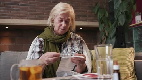 Senior Woman Taking Pills in Cozy Home Interior