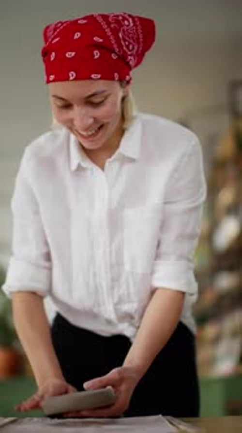 Artisan with Joyful Expression Molding Clay on Table in Creative Pottery Workshop