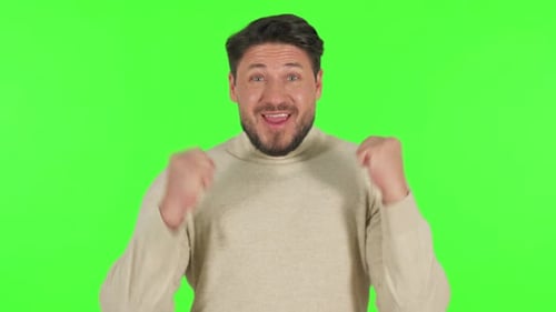 Mann mittleren Alters feiert Erfolg auf grünem Hintergrund