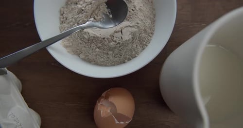 Ingredients and utensils for baking mug cake. Dolly backwards, top view