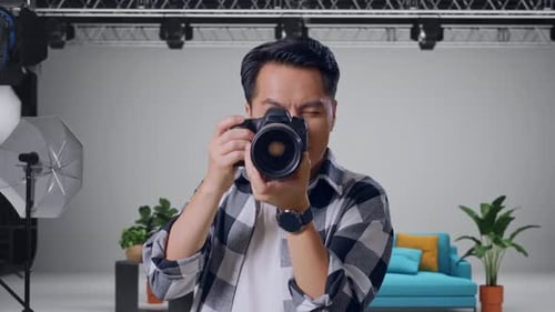 Asian Photographer Using A Camera Taking Pictures And Smiling In The Studio
