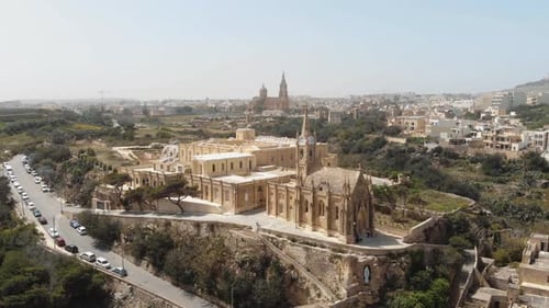 4k aerial drone footage circling the Church Ghajnsielem Parish in the Mediterranean town of Mgarr -