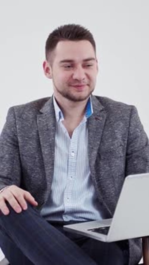 Young Man Works on Laptop Indoors