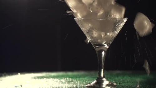 Der Barkeeper kreiert einen schönen alkoholischen Cocktail im Martiniglas mit Eis