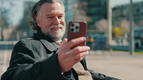 Senior Man Uses Smartphone in Urban Setting