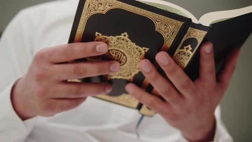 Man Reads Religious Book with Gold Detail