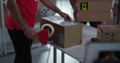 Caucasian Corporate Couple of Two Men in Uniform Collecting Delivery Boxes with Customer Parcels in