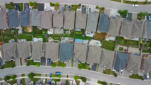 Aerial view of suburban neighborhood, flying right over houses.