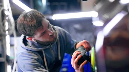 the Car Mechanic at a Service Station Doing the Final Polishing to Shine