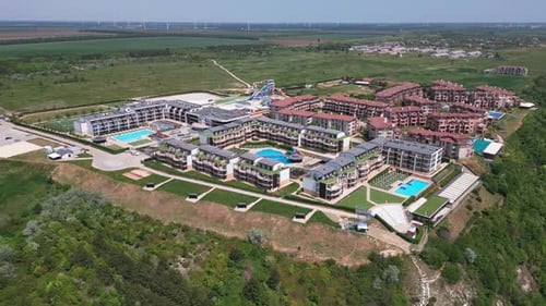 Aerial View of a Massive Modern Hotel Complex Sprawled Beneath Boasting a Myriad of Swimming Pools