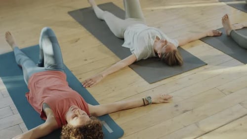 Adults Practicing Yoga Poses in Bright Studio
