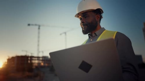 Hochqualifizierter ausländischer professioneller Baumeister mit Laptop auf der Baustelle Porträt eines Profis